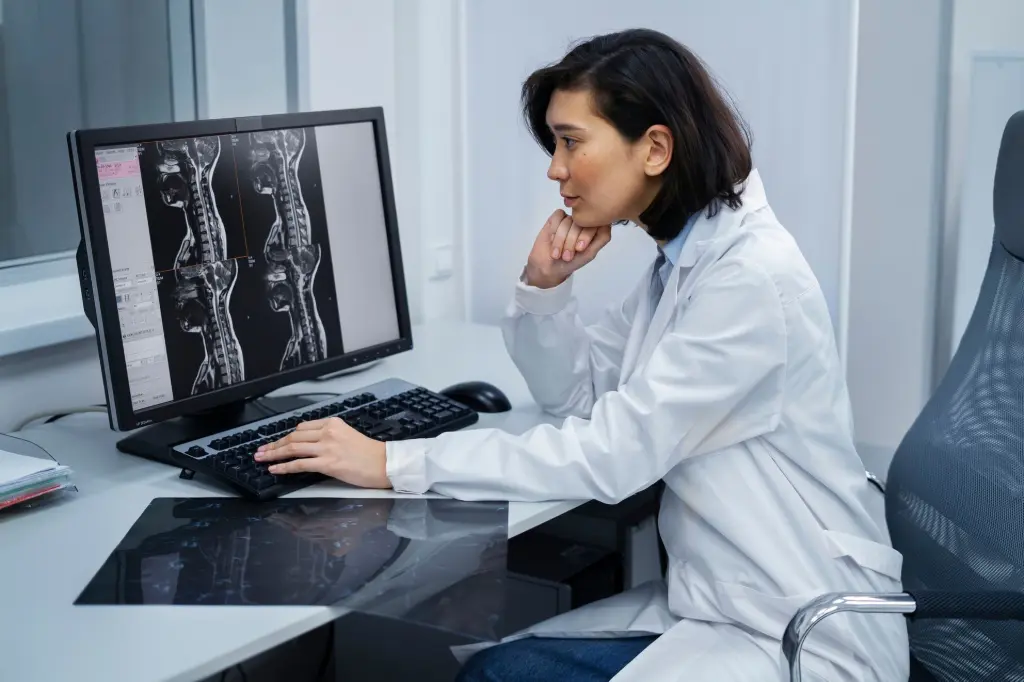 Radiologist analyzing spinal MRI scans using PACS viewer software